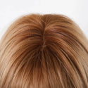 Top view of honey brown bang wig highlighting natural-looking part and layered volume on mannequin