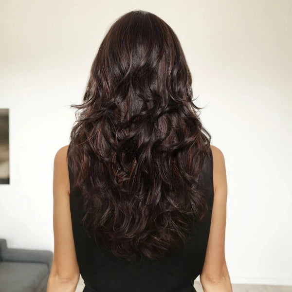 Woman with long, wavy dark brown wig from behind in a neutral setting