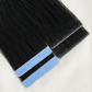 Black invisible tape in hair extensions with blue adhesive strips on a white background