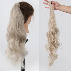 Blonde hair extension worn by a person and held by a hand on a white background