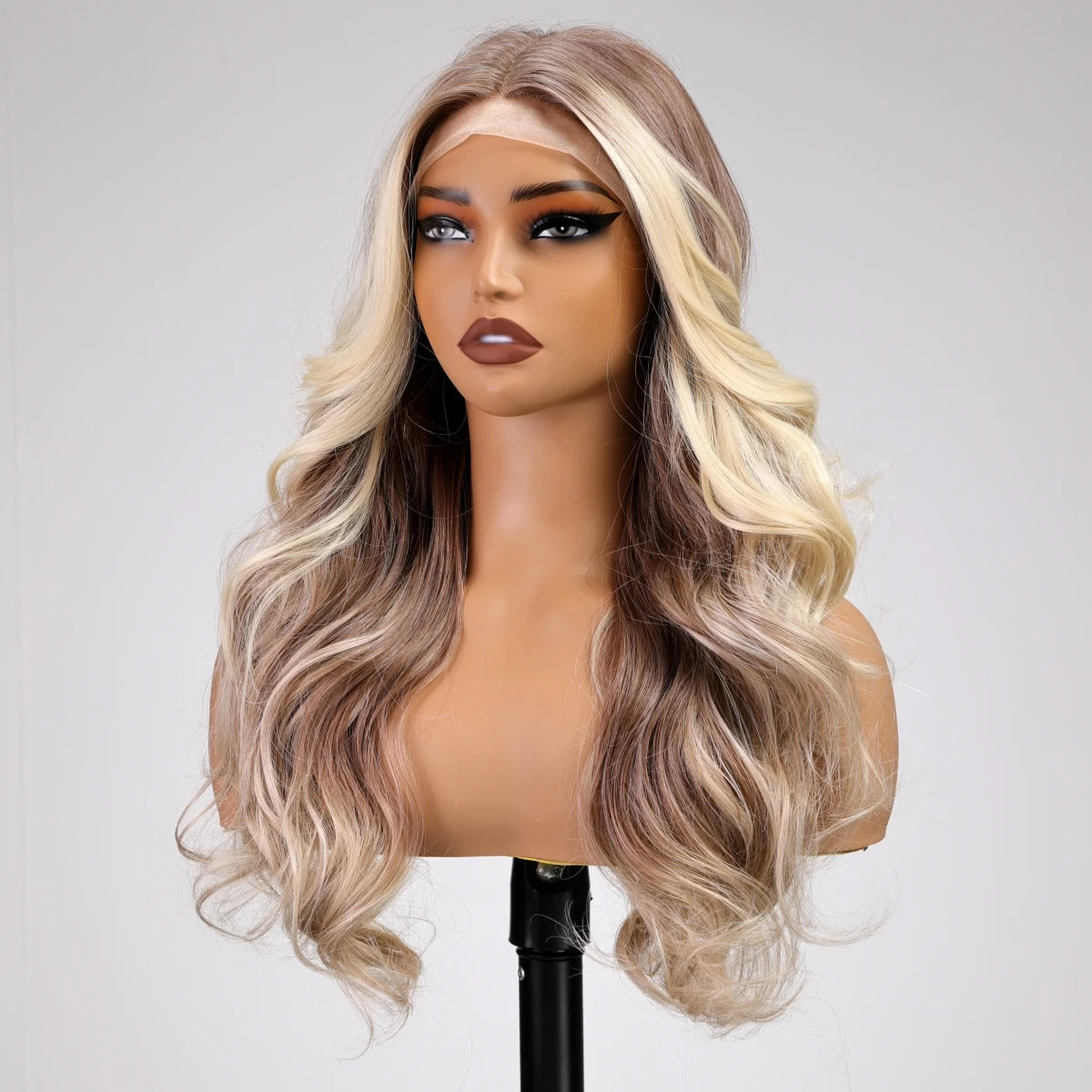 Blonde wig on a mannequin head against a plain background