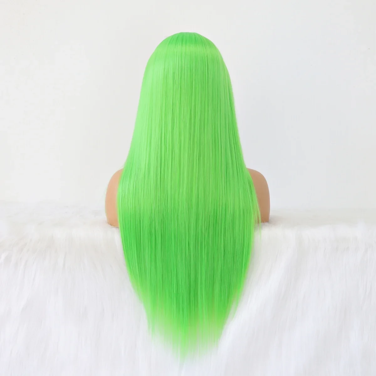 Green wig on a mannequin head against a white background