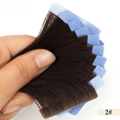 Hand holding a hair color swatch with brown hair extensions against a white background