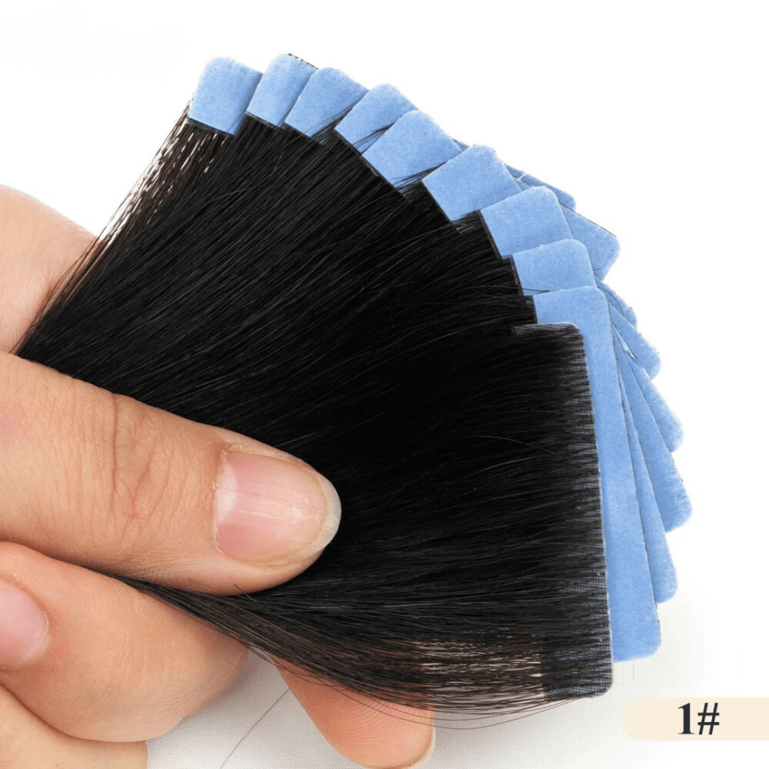 Hand holding a set of black hair extensions against a white background