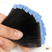 Hand holding a set of black hair extensions against a white background