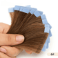 Hand holding hair extensions with color swatches against a white background