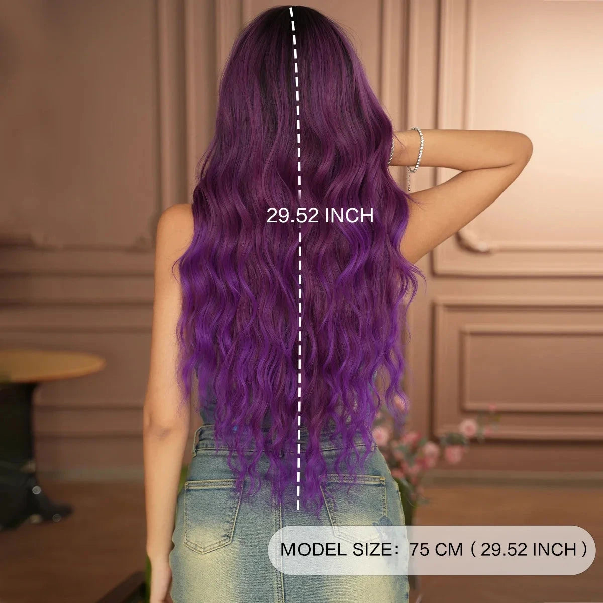 Person with purple wig showing hair length measurement, standing indoors.