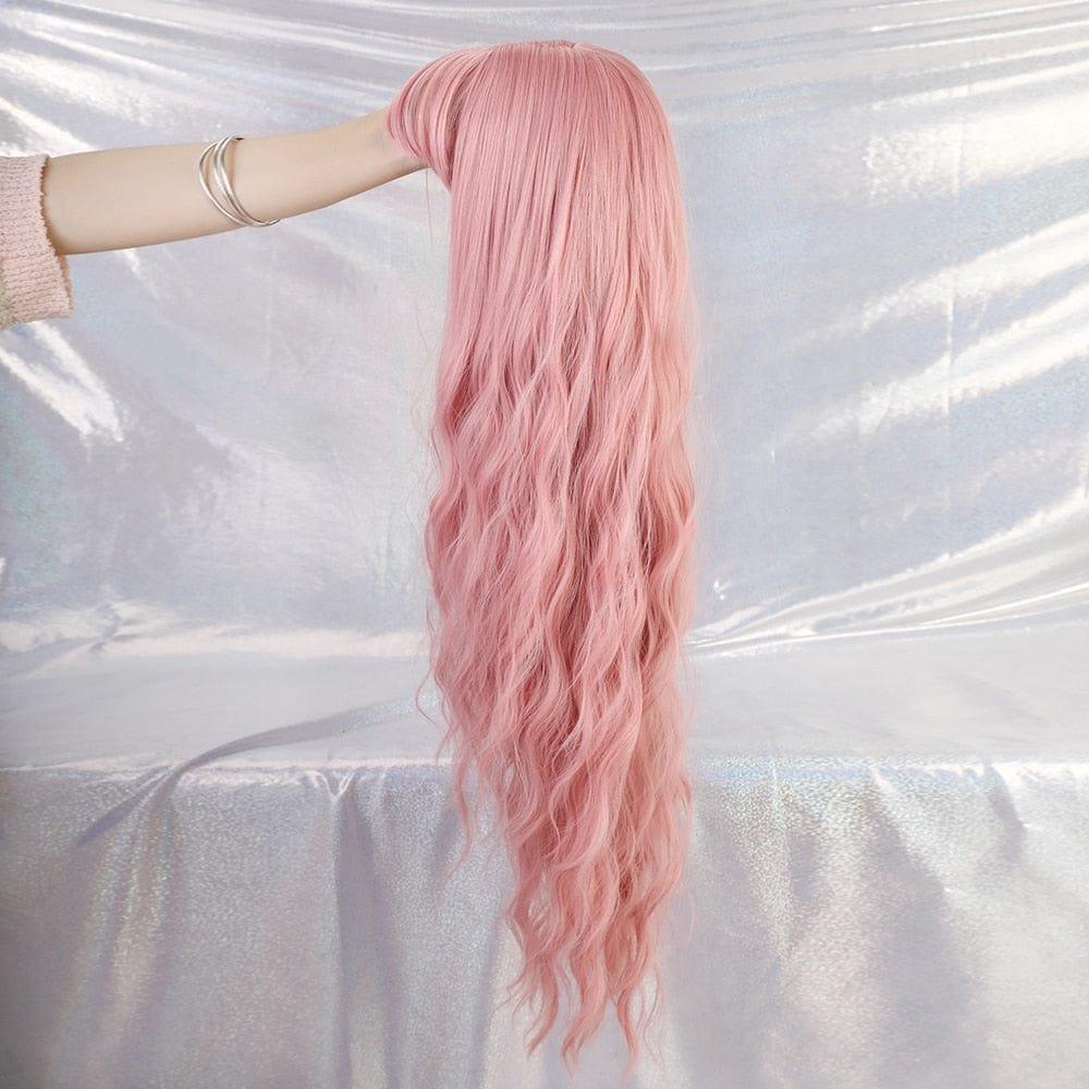 Pink wig held by a person against a white background