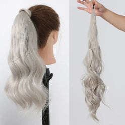 Silver hair ponytail extension on a mannequin head and held by a hand against a white background