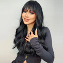 Woman wearing a long black wig and dark makeup against a light gray background