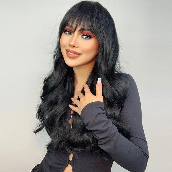 Woman wearing a long black wig and dark makeup against a light gray background