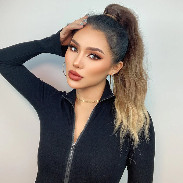 Woman with a high ponytail extension wearing a black outfit against a plain background