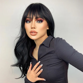 Woman with black wig with bangs and stylish makeup wearing a dark outfit against a plain background