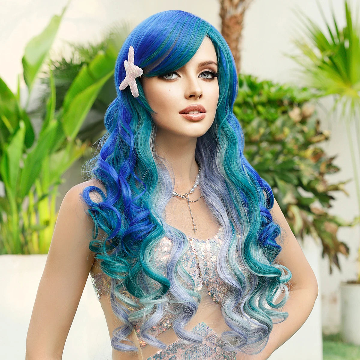 Woman with blue and green wig wearing a starfish hair accessory in a garden setting
